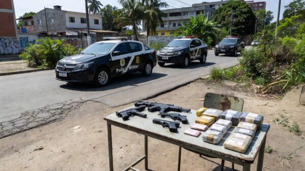 Viaturas policiais e armas e drogas apreendidas em operação contra quadrilha