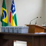 Salão de convenção política em Rondônia com bandeiras e urnas eleitorais