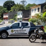 Viatura da Polícia Civil e motocicleta em Porto Velho durante operação contra golpe de seguro