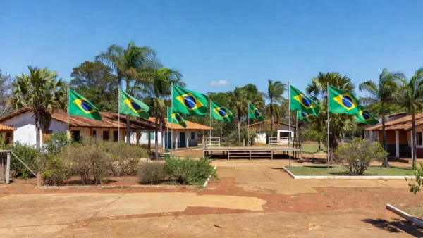 Praça pública em Colorado do Oeste com bandeiras do Brasil durante lançamento de candidaturas políticas